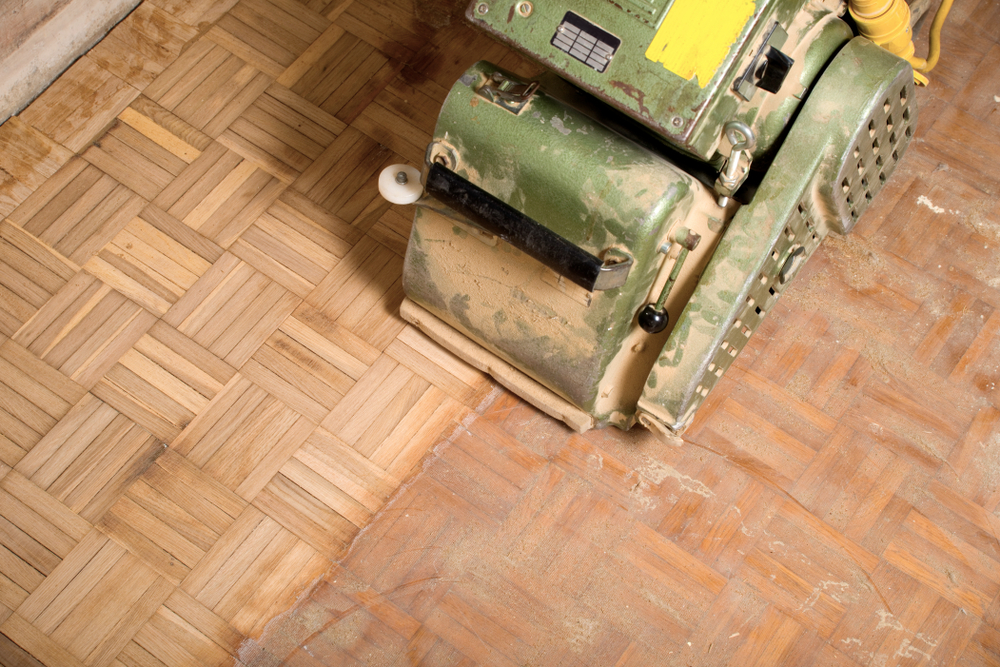 Professional floor sanding machine restoring a wooden parquet floor at a school in Edmonton N18, London.